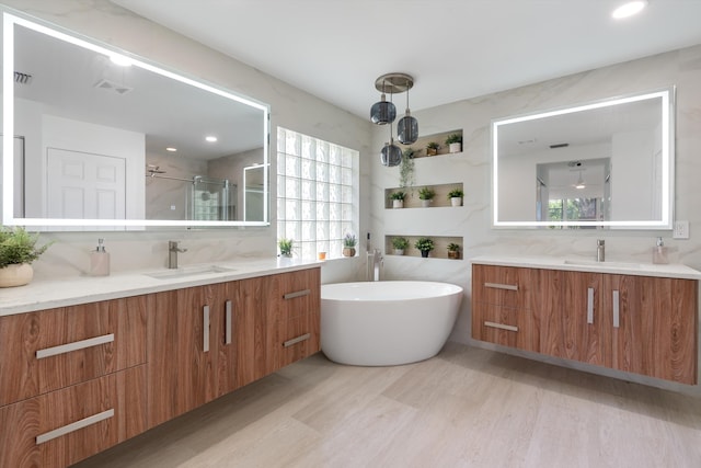 bathroom featuring decorative backsplash, hardwood / wood-style floors, vanity, and independent shower and bath