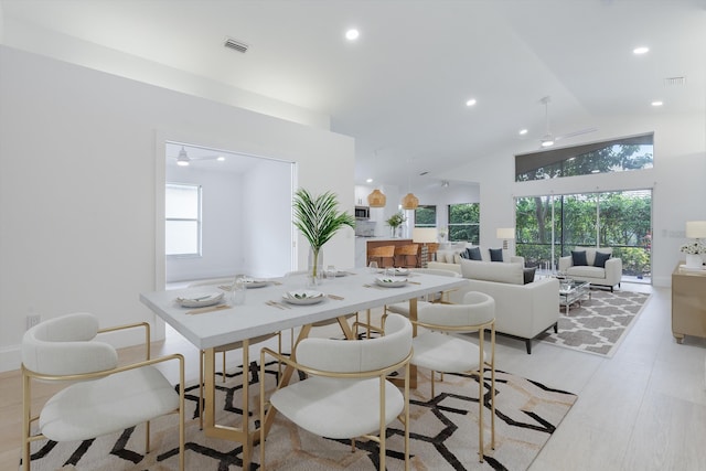 dining area with ceiling fan, a healthy amount of sunlight, and lofted ceiling