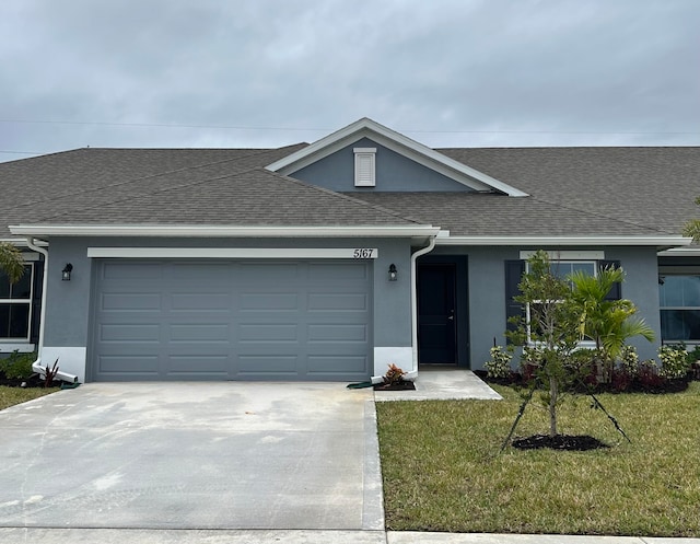 ranch-style house featuring a garage and a front lawn