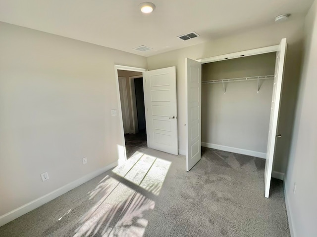 unfurnished bedroom with a closet and light colored carpet