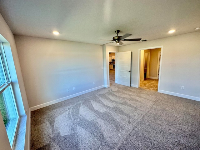 unfurnished bedroom with ceiling fan, light colored carpet, and a spacious closet