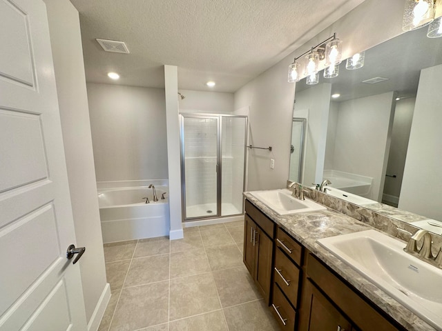 bathroom featuring tile patterned flooring, vanity, a textured ceiling, and separate shower and tub