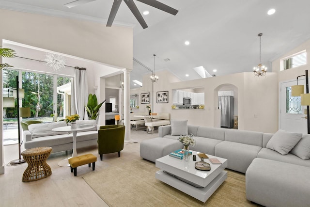 living room with light hardwood / wood-style flooring, high vaulted ceiling, ornamental molding, and an inviting chandelier