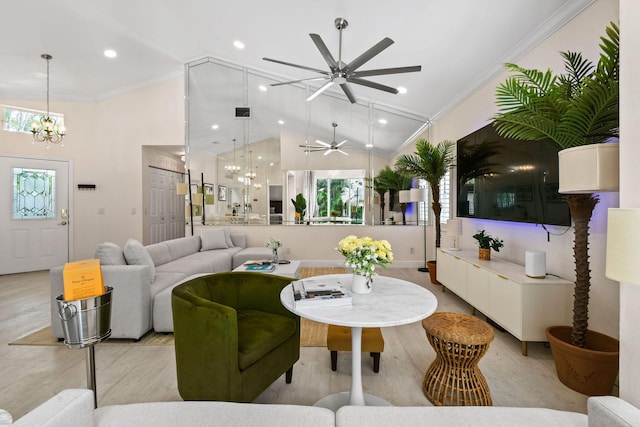 living room with ceiling fan with notable chandelier, a healthy amount of sunlight, ornamental molding, and light hardwood / wood-style flooring