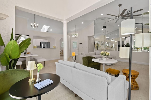 living room featuring lofted ceiling, light hardwood / wood-style floors, and ceiling fan with notable chandelier