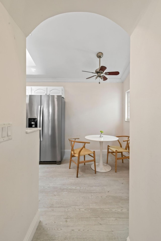 dining space featuring ceiling fan, light wood-type flooring, and crown molding