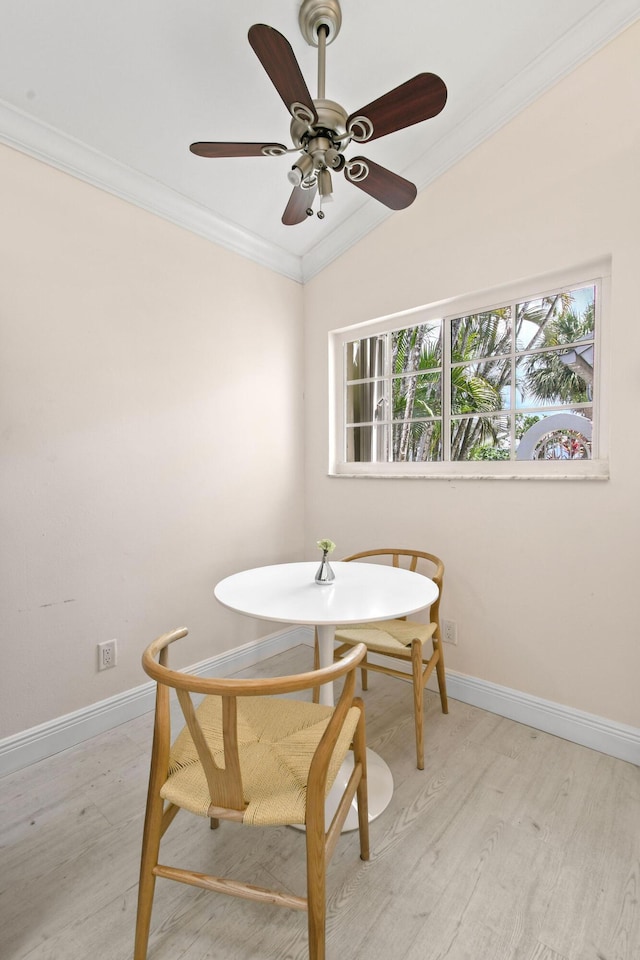 dining space with light hardwood / wood-style floors, vaulted ceiling, and ornamental molding