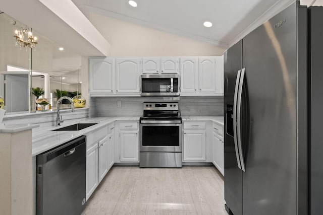 kitchen featuring white cabinets, sink, lofted ceiling, and stainless steel appliances