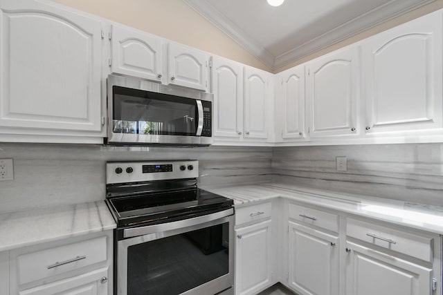 kitchen featuring lofted ceiling, white cabinetry, backsplash, and appliances with stainless steel finishes