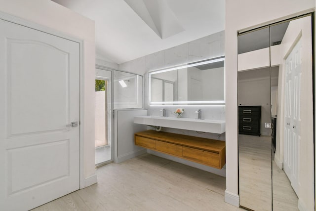 bathroom featuring hardwood / wood-style flooring, vanity, and lofted ceiling