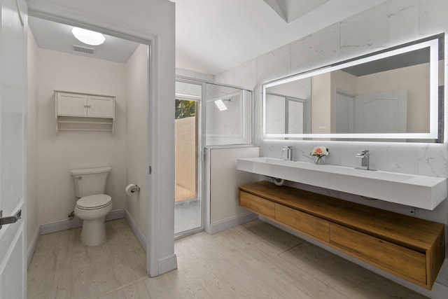 bathroom featuring hardwood / wood-style floors, vanity, toilet, and a shower with door