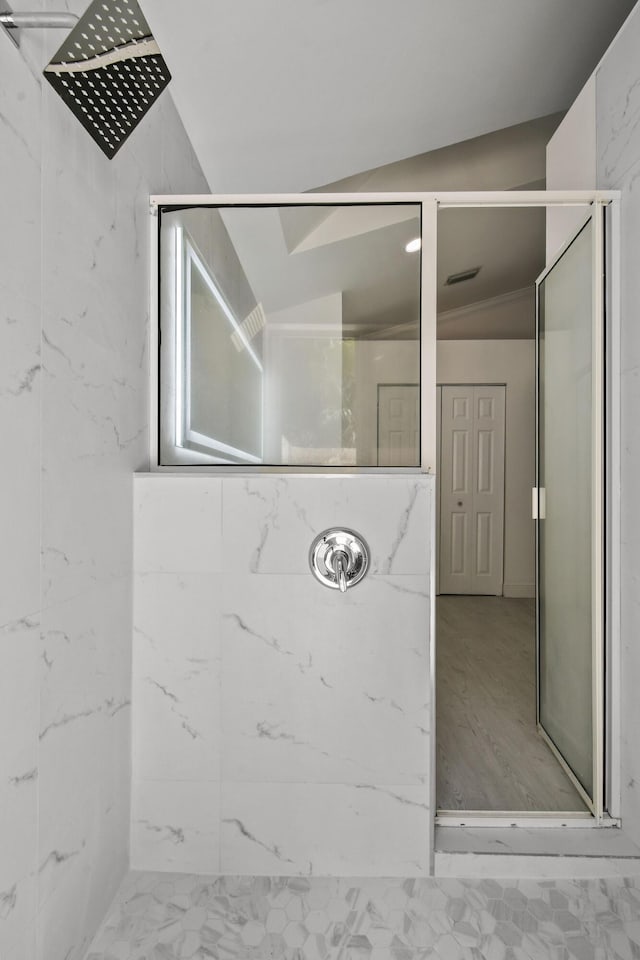 bathroom featuring hardwood / wood-style flooring, vaulted ceiling, and walk in shower