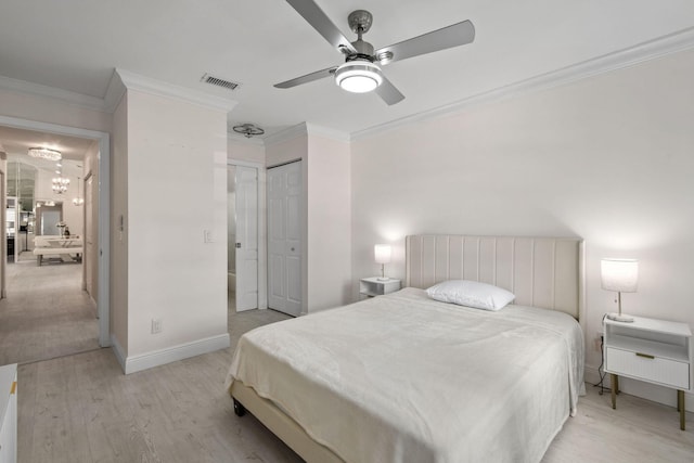 bedroom with ceiling fan with notable chandelier, light hardwood / wood-style floors, and crown molding