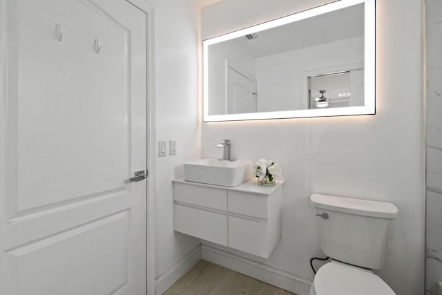 bathroom featuring hardwood / wood-style floors, vanity, and toilet