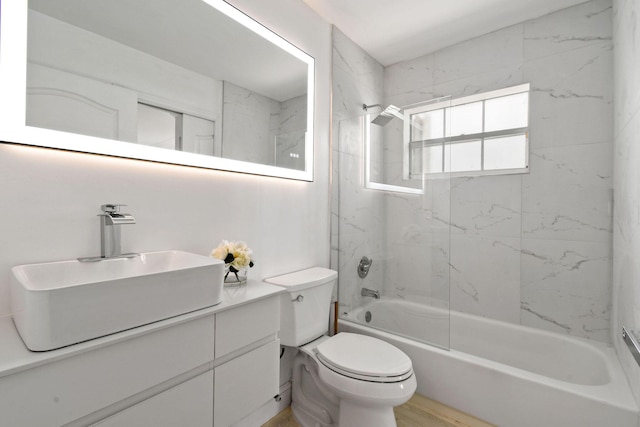 full bathroom featuring hardwood / wood-style flooring, vanity, toilet, and tiled shower / bath