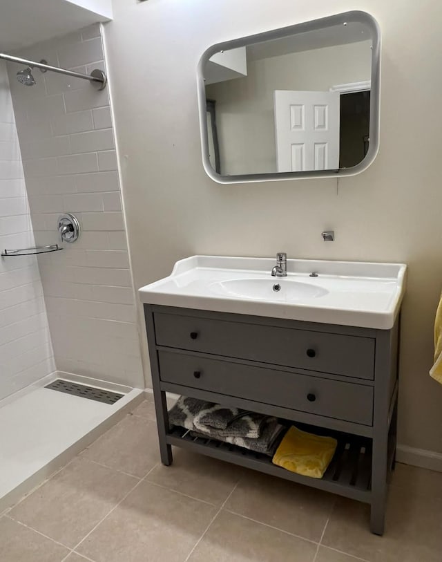 bathroom featuring a tile shower, vanity, and tile patterned flooring