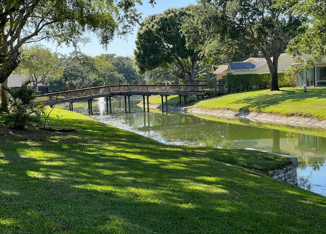 surrounding community with a yard and a water view