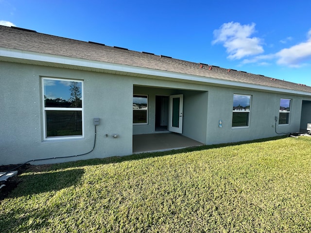 rear view of house featuring a yard and a patio