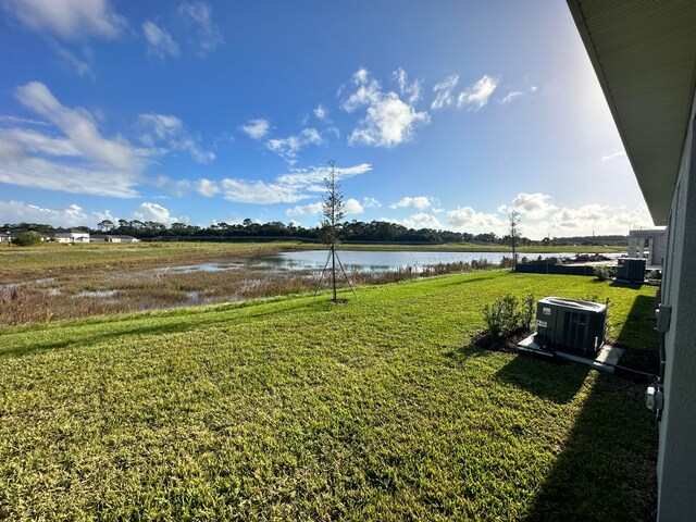 view of yard featuring central AC unit and a water view