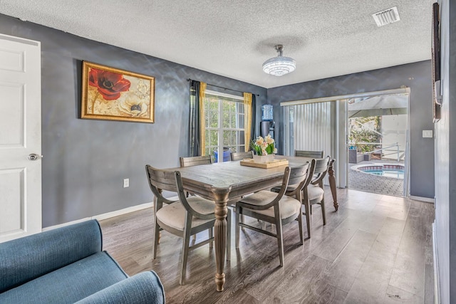 dining room featuring hardwood / wood-style floors and a textured ceiling