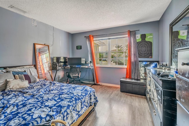 bedroom with wood-type flooring and a textured ceiling