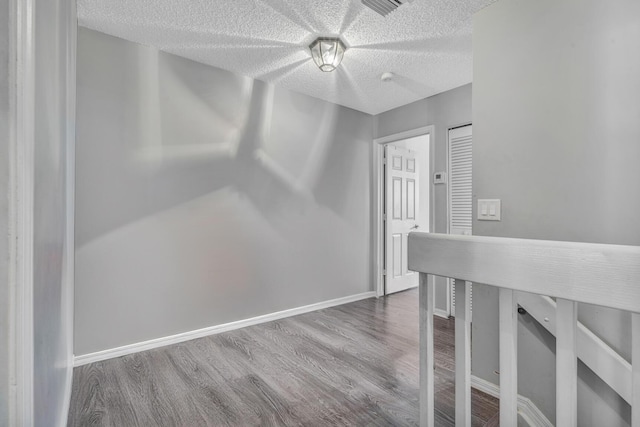 interior space with wood-type flooring and a textured ceiling