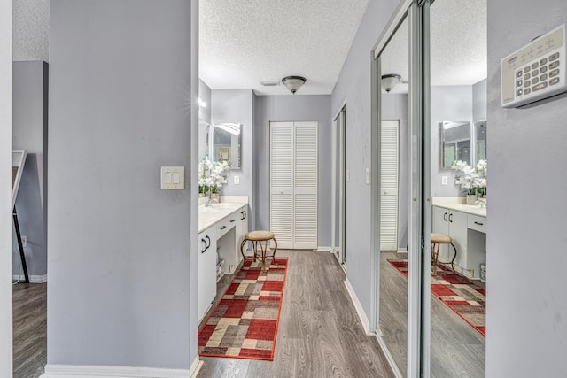 bathroom featuring hardwood / wood-style flooring, vanity, and a textured ceiling