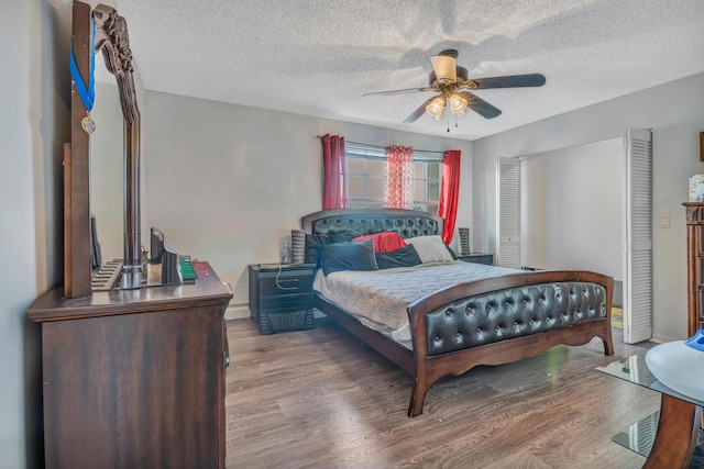 bedroom featuring ceiling fan, wood-type flooring, and a textured ceiling