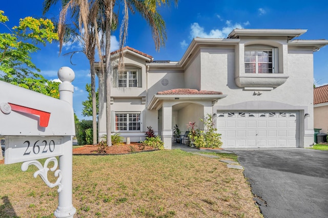 mediterranean / spanish-style home featuring a front lawn and a garage