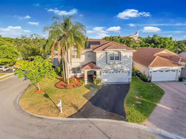 mediterranean / spanish home with a front lawn and a garage