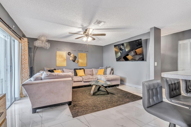 living room featuring ceiling fan and a textured ceiling