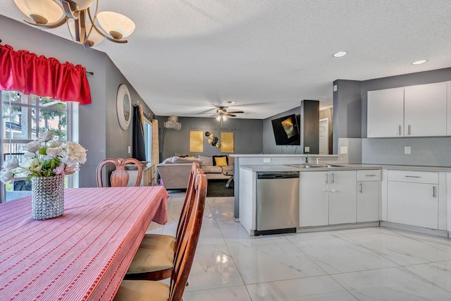 kitchen featuring kitchen peninsula, stainless steel dishwasher, ceiling fan, a textured ceiling, and white cabinetry