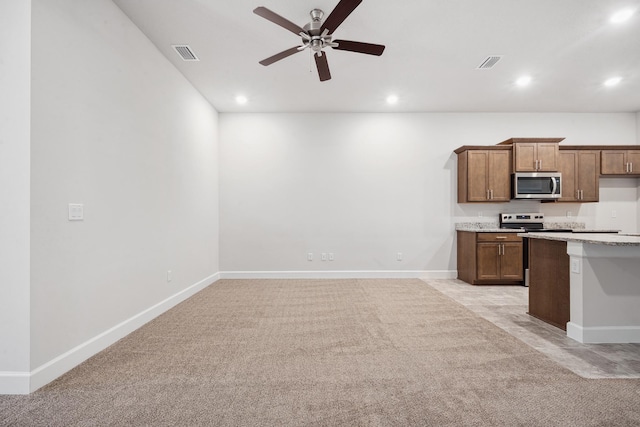 kitchen with ceiling fan, light colored carpet, and stainless steel appliances