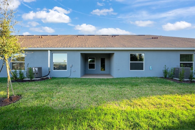 rear view of house with a yard, central AC, and a patio area