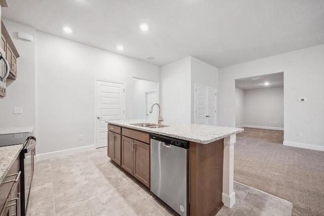 kitchen featuring light carpet, appliances with stainless steel finishes, a kitchen island with sink, and sink