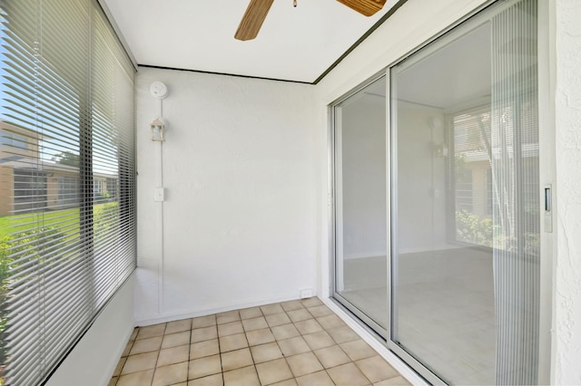 unfurnished sunroom featuring ceiling fan