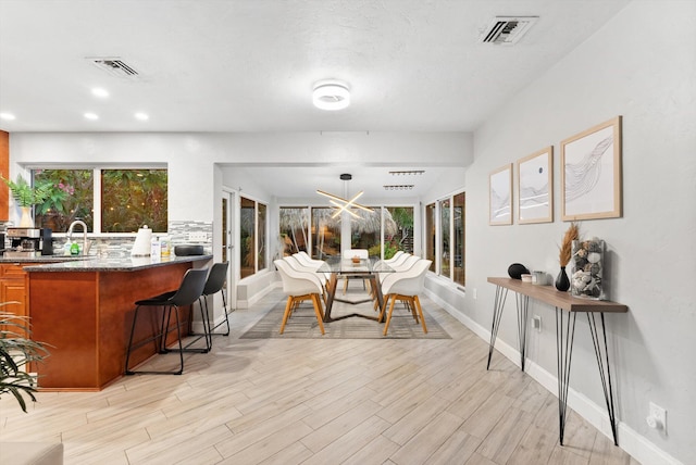 dining space with a healthy amount of sunlight and light wood-type flooring