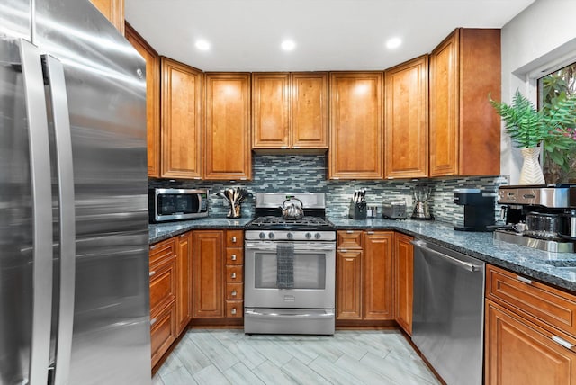 kitchen featuring tasteful backsplash, dark stone counters, and appliances with stainless steel finishes