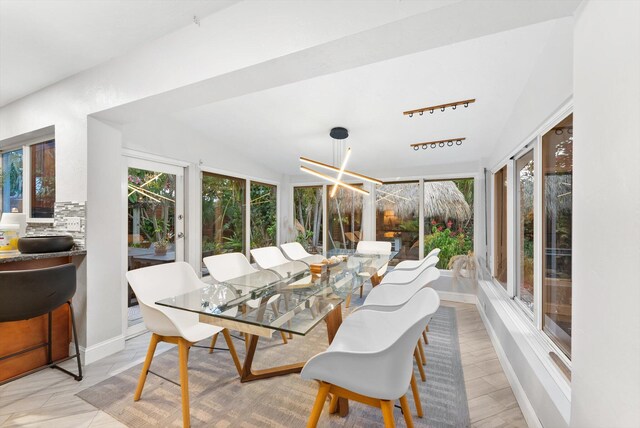 sunroom / solarium with an inviting chandelier and lofted ceiling