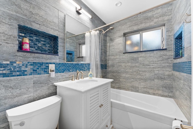 full bathroom featuring a healthy amount of sunlight, oversized vanity, tile walls, and toilet