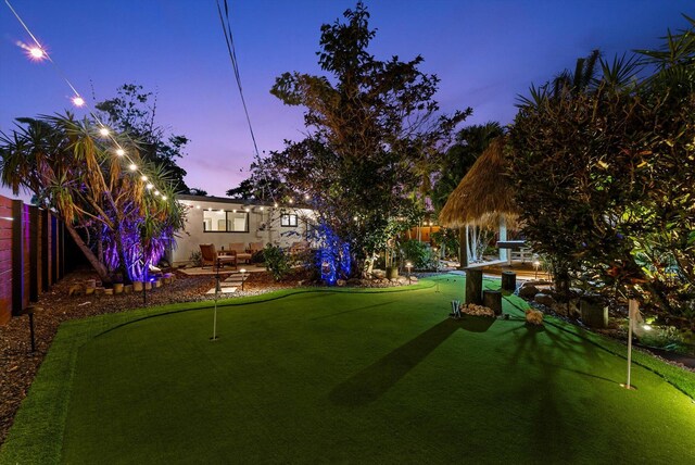 yard at dusk featuring a patio