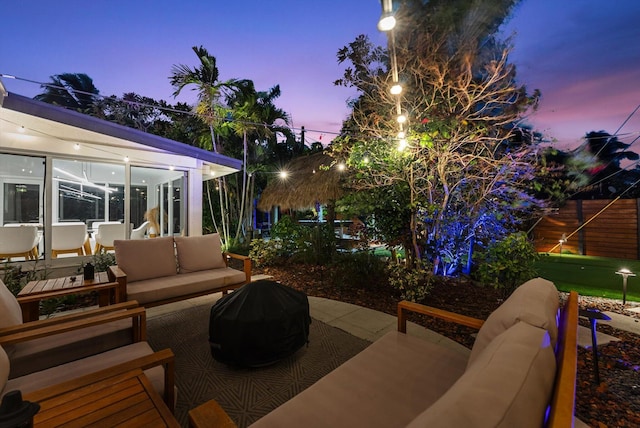 patio terrace at dusk featuring an outdoor living space and a grill