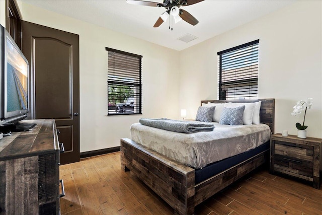 bedroom with hardwood / wood-style flooring, ceiling fan, and multiple windows