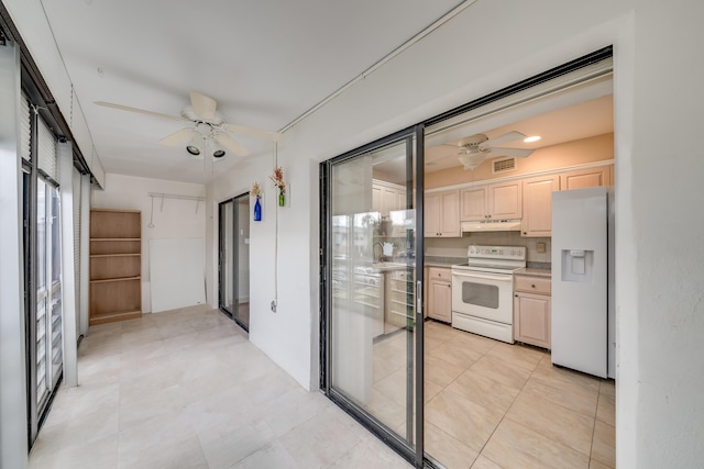 kitchen featuring ceiling fan, light brown cabinetry, light tile patterned flooring, and white appliances