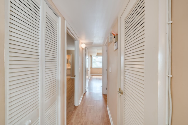 corridor with light hardwood / wood-style floors