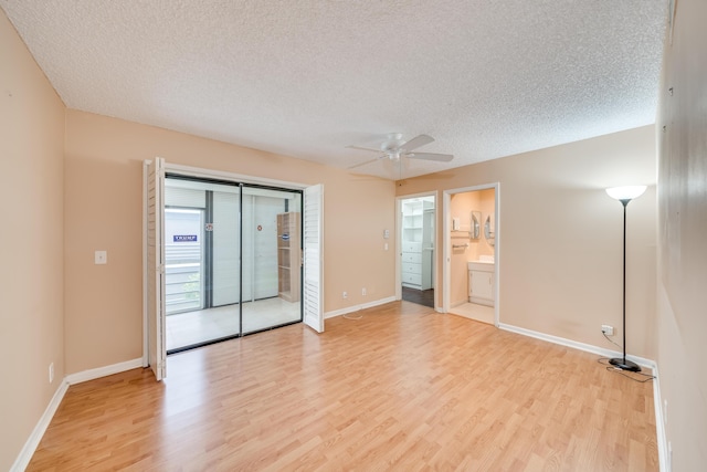 unfurnished room featuring ceiling fan, light wood-type flooring, and a textured ceiling