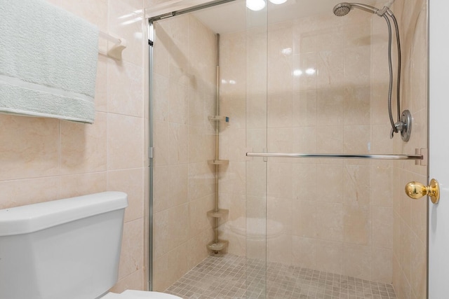 bathroom featuring toilet and an enclosed shower