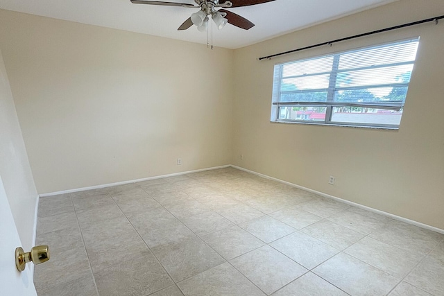 tiled spare room with ceiling fan