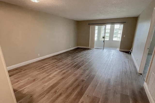 unfurnished room featuring a textured ceiling and hardwood / wood-style flooring