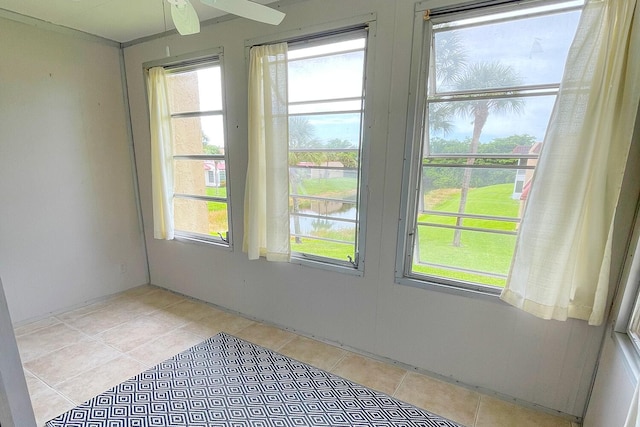 spare room with ceiling fan and a water view